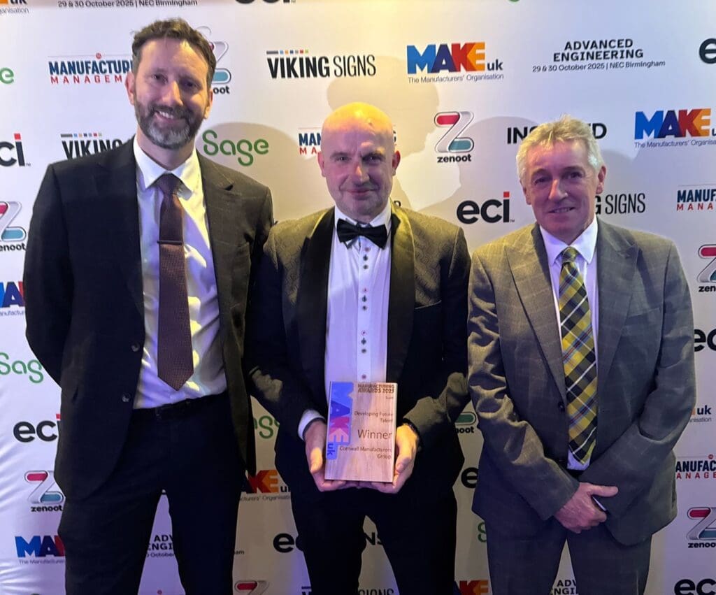 Three individuals holding award